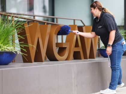 A worker cleans the WGAW logo displayed outside Writers Guild of America West headquarters