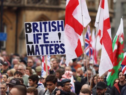 LONDON, ENGLAND - OCTOBER 26: Supporters of Tommy Robinson wave flags as they attend a mar
