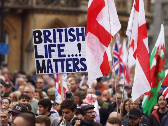LONDON, ENGLAND - OCTOBER 26: Supporters of Tommy Robinson wave flags as they attend a mar