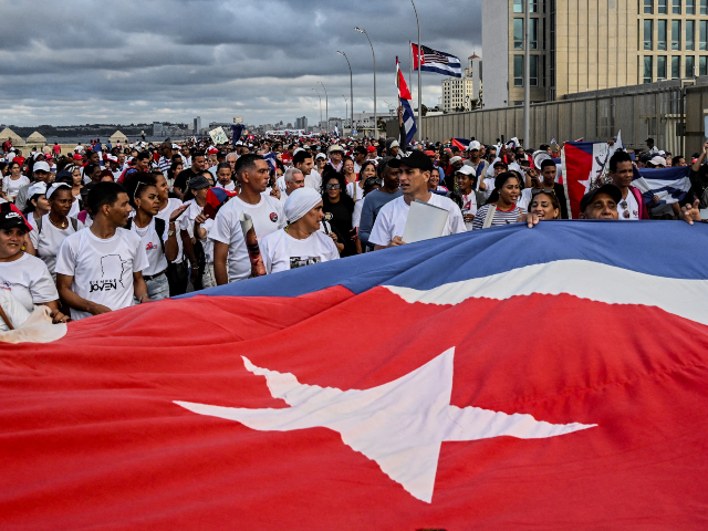 Cubans walk past the US embassy as they march along Havana's promenade on December 20, 202
