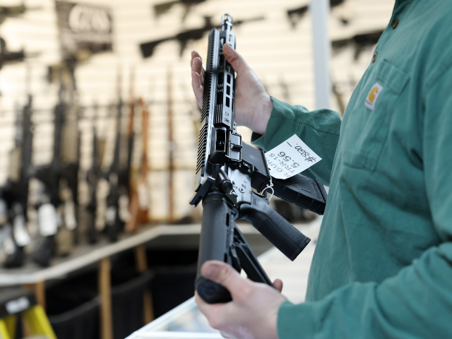 A customer inspects an R Guns-brand TRR15 model semi-automatic rifle at R Guns, April 29,