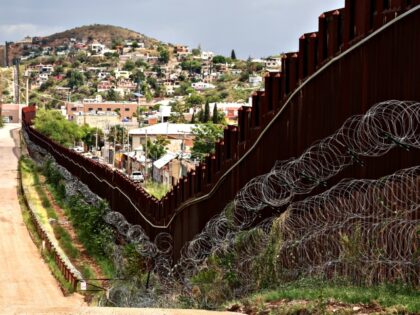 Spool sof razor wire line the US-Mexico border wall in Nogales, Arizona on September 17, 2