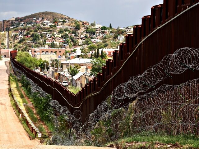 Spool sof razor wire line the US-Mexico border wall in Nogales, Arizona on September 17, 2