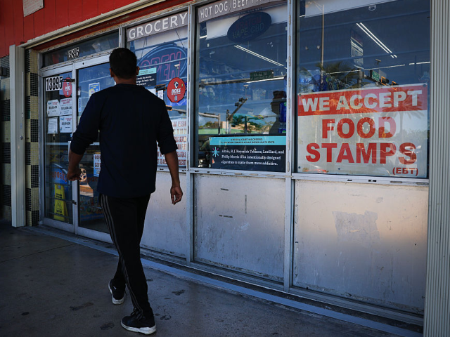 MIAMI, FLORIDA - OCTOBER 31: A 'We Accept Food Stamps' sign hangs in the window of a groce