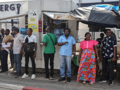 Residents watch as the motorcade of France's President Emmanuel Macron passes by in Gabon