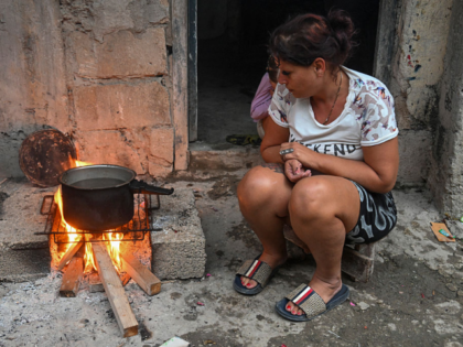 A woman cooks over a wood fire during a blackout in the Poey neighborhood of Havana on Jan