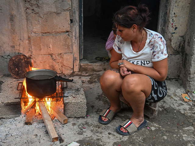 A woman cooks over a wood fire during a blackout in the Poey neighborhood of Havana on Jan