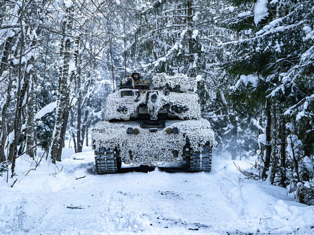 A Challenger 2 main battle tank in arctic camouflage moves onto the battlefield on the Tap