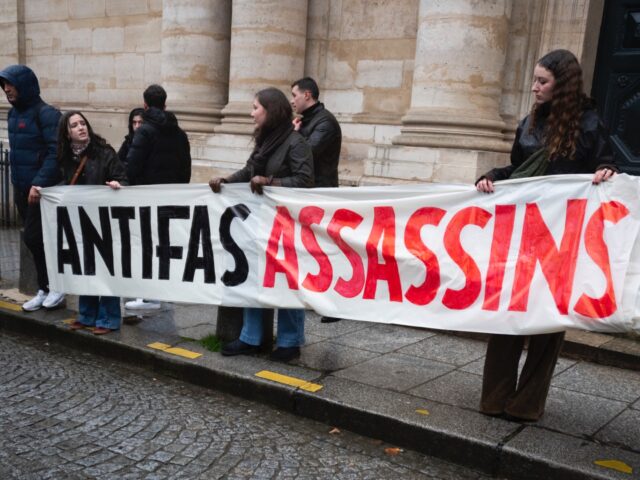 Demonstrators stand behind a banner reading Antifa murderers, justice for Quentin during a