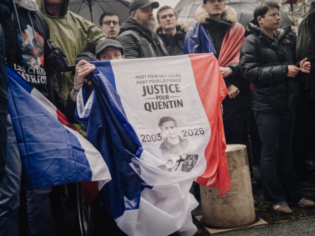 A person in the crowd is holding a French flag that reads Mort pour nos soeurs mort pour l