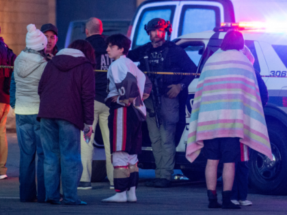 People stand outside a police perimeter they created around the Dennis M. Lynch Arena wher