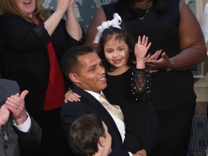 WASHINGTON, DC - FEBRUARY 24: Marcus Coleman holds his daughter Dalilah Coleman as U.S. Pr