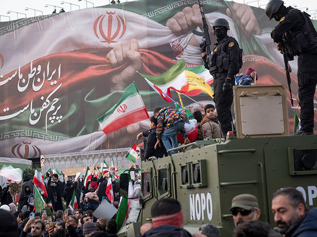 Armed members of Iran's police special forces monitor an area while standing on an armored