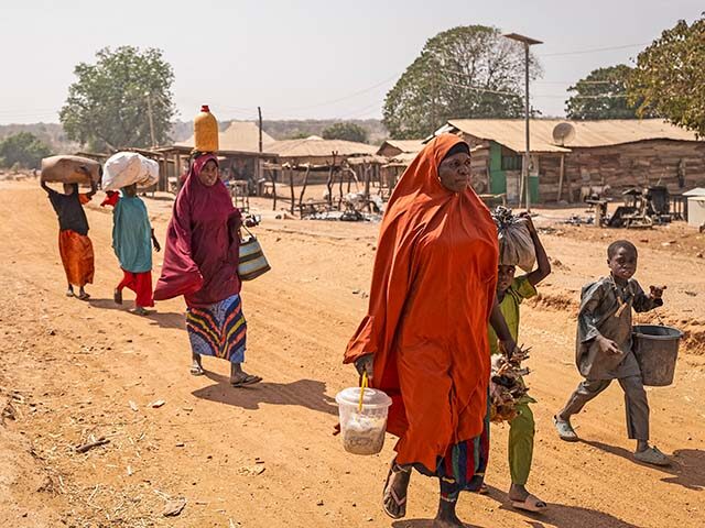 Residents carry their belongings as they flee the area following the attack in Woro, Kwara