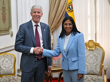 US Secretary of Energy Chris Wright (L) shakes hands with Venezuela's acting president Del
