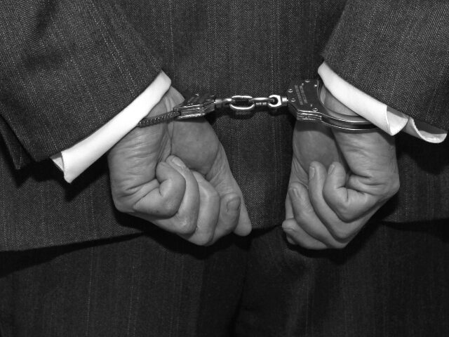 Handcuffed man in suit