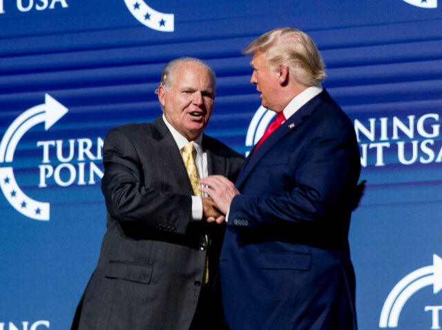 President Donald Trump, right, shakes hands with radio personality Rush Limbaugh, left, as