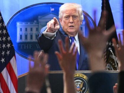 Members of the media raise their hands to ask questions to US President Donald Trump durin