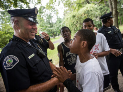 Officer Jim Lopez (L), of the Camden County Police Department (CCPD), wrangles with Omar H