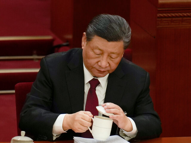 Chinese President Xi Jinping drinks a cup of tea during the opening session of the Nationa