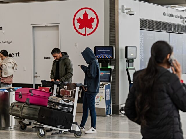 Travelers near the Air Canada check-in area at Toronto Pearson International Airport in Mi