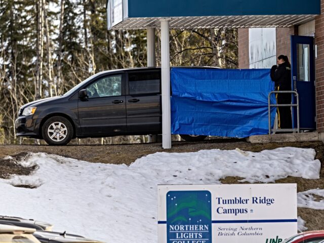 Police officers and investigators work outside the high school building where a mass shoot