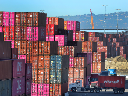 A trucker moves a load amidst stacks of shipping containers at the Port of Long Beach on J