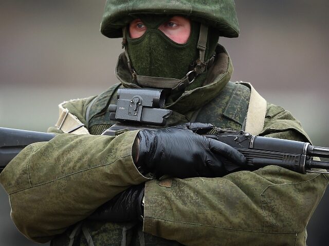 SIMFEROPOPL, UKRAINE - MARCH 12: Armed men believed to be Russian military patrol outside