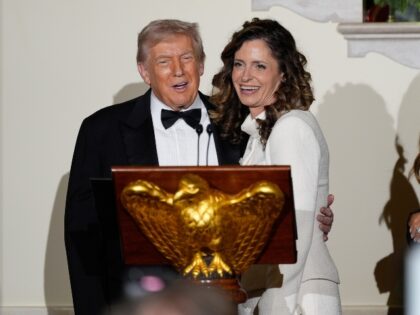 Accompanied by first lady Melania Trump, President Donald Trump stands at the podium with