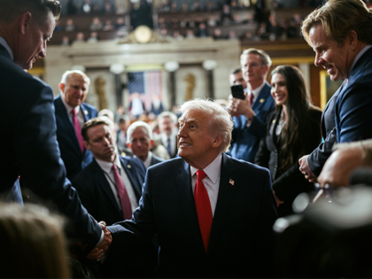 President Donald Trump shakes hands as he enters the House Chamber to deliver his State of