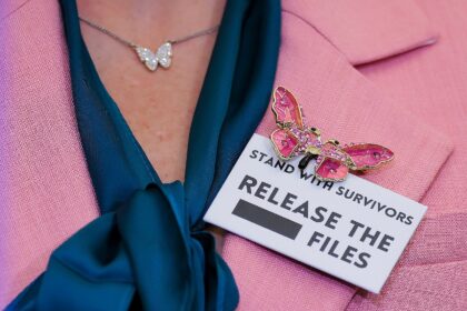 Danielle Bensky, a Jeffrey Epstein survivor, wears a butterfly pin and a 'release the