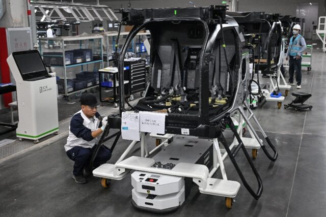 Employees work on an assembly line for electric flying cars, which will require critical m