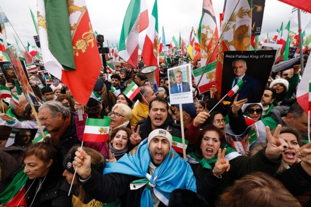 Iranian demonstrators hold flags and posters depicting Iran's former crown prince and