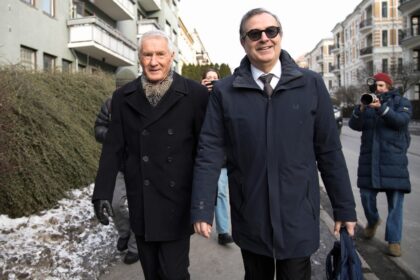 Norway's former prime minister Thorbjorn Jagland (L) and his lawyer (R) put on smiles