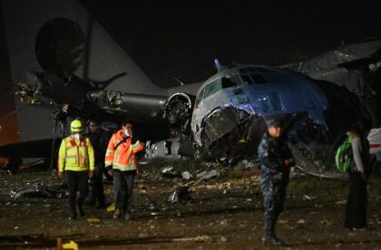 Responders study the wreckage of a Bolivian military transport plane that crashed near La