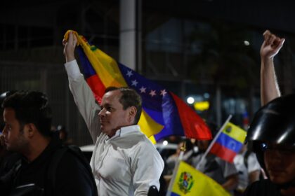 Venezuelan opposition politian leader Juan Pablo Guanipa waves a national flag after his r