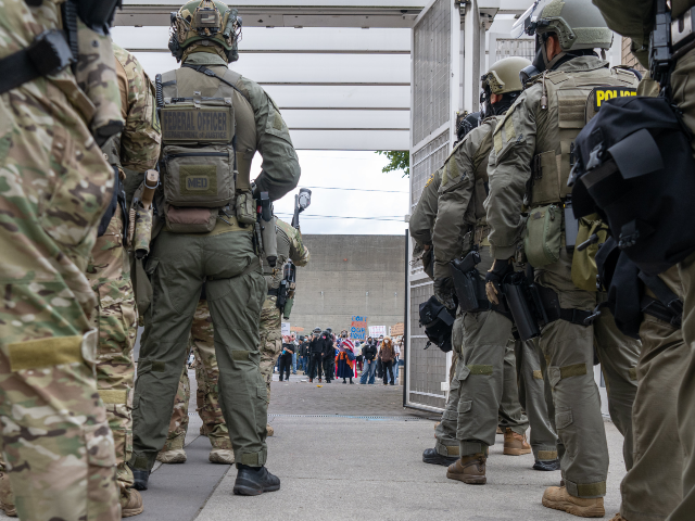Protesters amass on the street as federal officers from the U.S. Bureau of Prisons, U.S. C