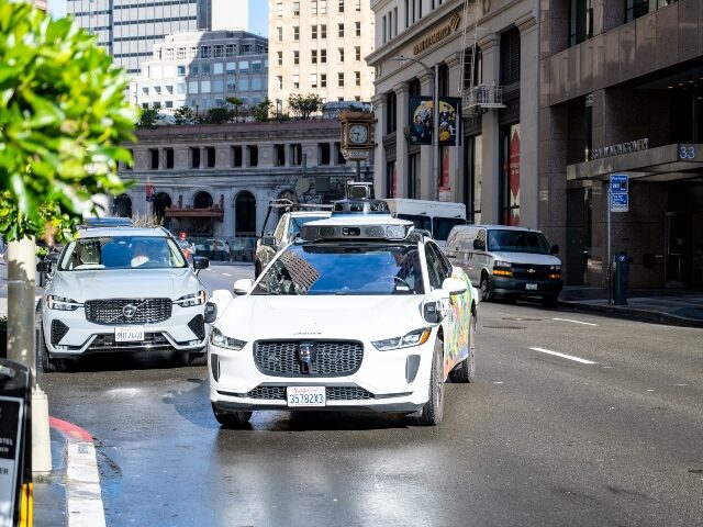 A Waymo robotaxi pulling into a drop off zone