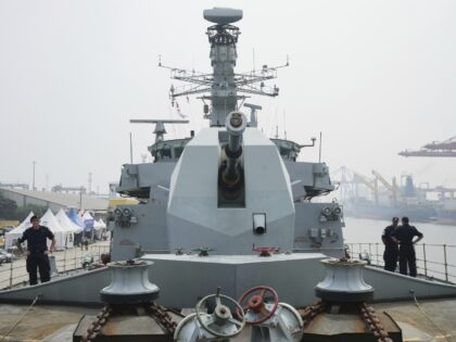 Sailors stand near the main gun of Royal Navy frigate HMS Richmond during a port call at T