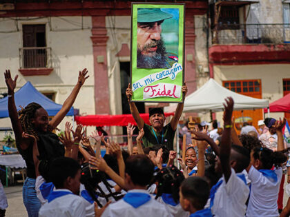 Title: Cuba Daily Life Image ID: 26063813908151 Article: A man holds up a photo of Cuba's