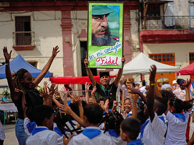 Title: Cuba Daily Life Image ID: 26063813908151 Article: A man holds up a photo of Cuba's