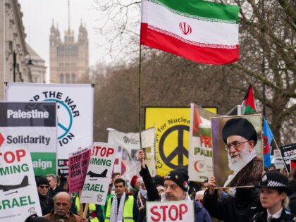 Demonstrators hold flags and placards as they attend a Stop the War Coalition march in Lon