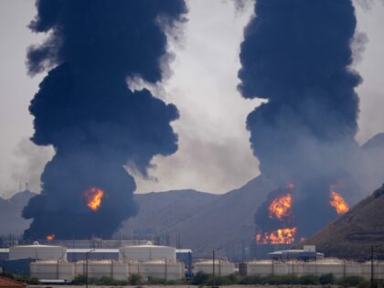 Plumes of smoke and fire rise after debris from an intercepted Iranian drone struck an oil