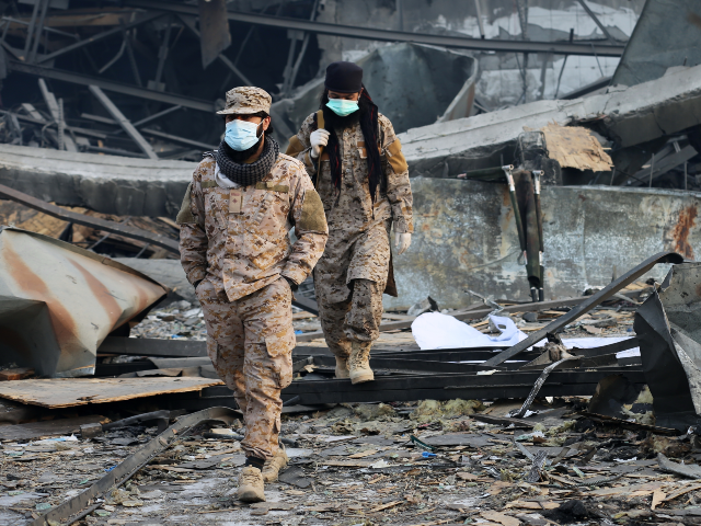 Taliban rescue workers inspect the site of a late-Monday airstrike at a drug rehabilitatio