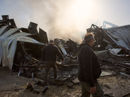 People inspect the site of a direct hit from an Iranian missile in central Israel, Wednesd