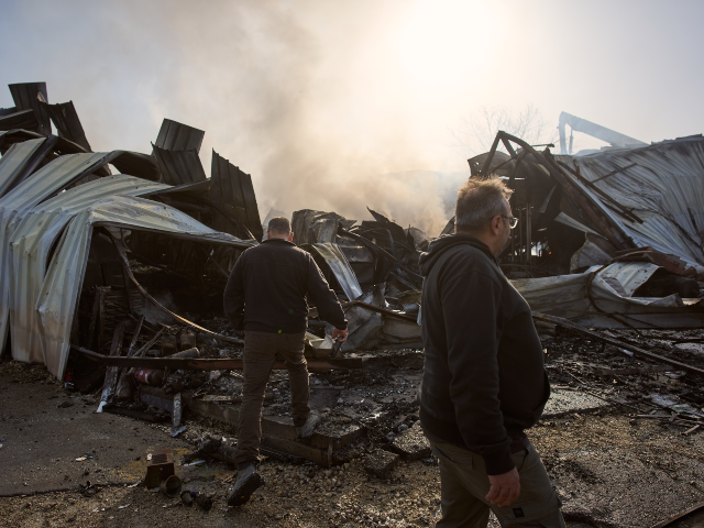 People inspect the site of a direct hit from an Iranian missile in central Israel, Wednesd