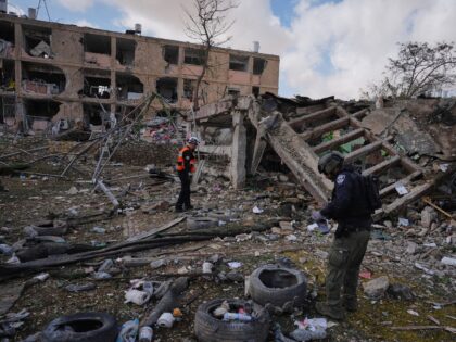Israeli security forces survey the site that was struck by an Iranian missile in Dimona, s
