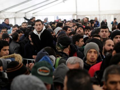 Hundreds of migrants waits in a tent to continue their registration process at the central