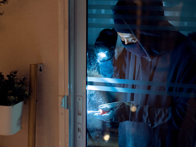 Burglar Breaking Into House - stock photo