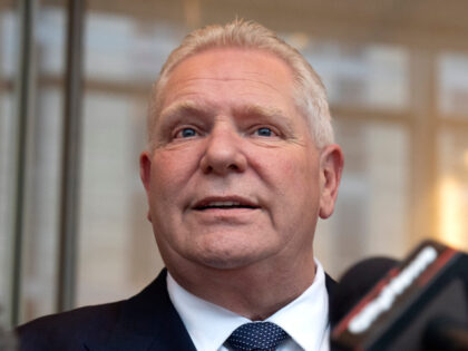 Ontario Premier Doug Ford, center, speaks with reporters as Stephen Lecce, right, Ontario&